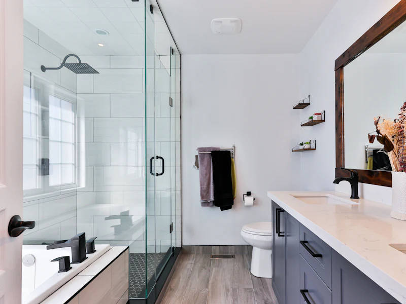 Spotless bathroom with a glass shower, white vanity, and bright natural light