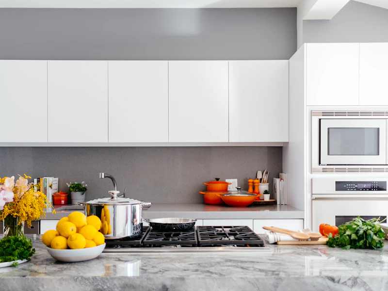 Clean, sunlit kitchen counter with fresh flowers and a bowl of lemons