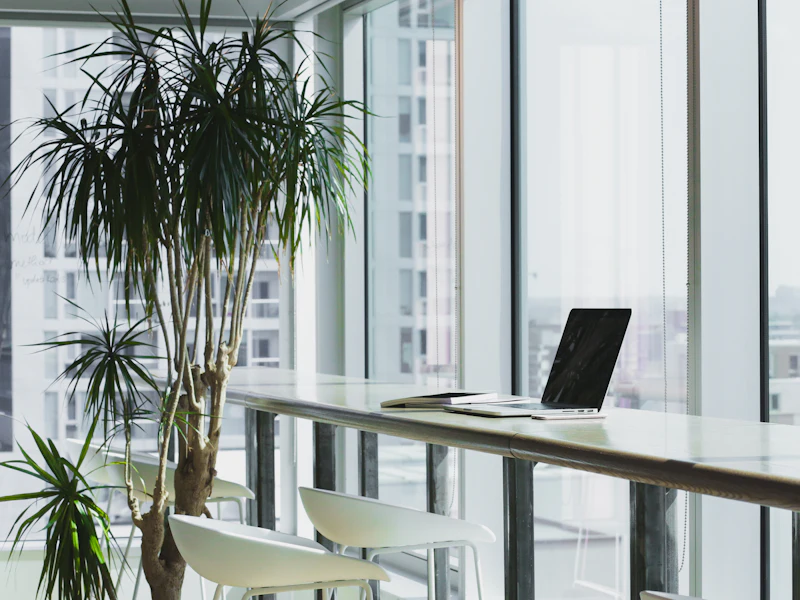 Clean, bright office workspace with a desk by large windows
