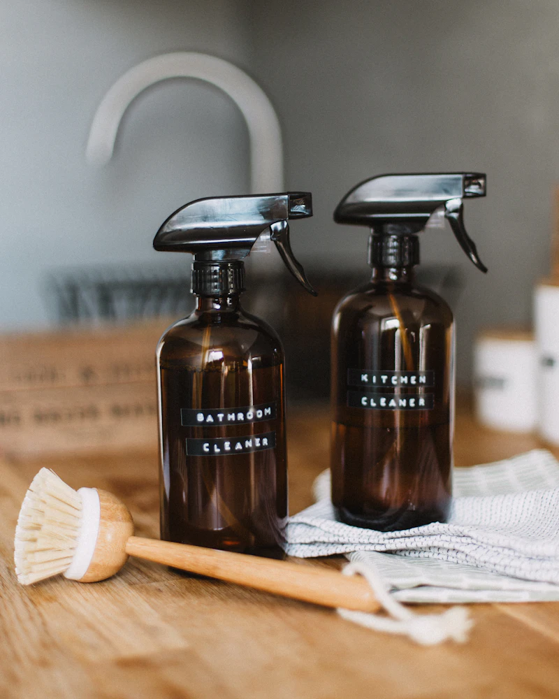 Glass spray bottles of kitchen and bathroom cleaner on a countertop